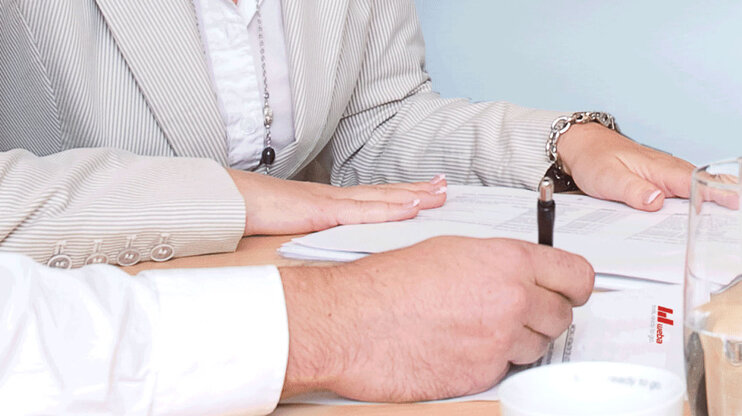 Two people reviewing documents and project files in an office.