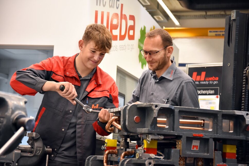  A toolmaking apprentice works on a miniature forming tool while the instructor watches attentively. weba Werkzeugbau offers apprenticeships in metal engineering in Steyr.
