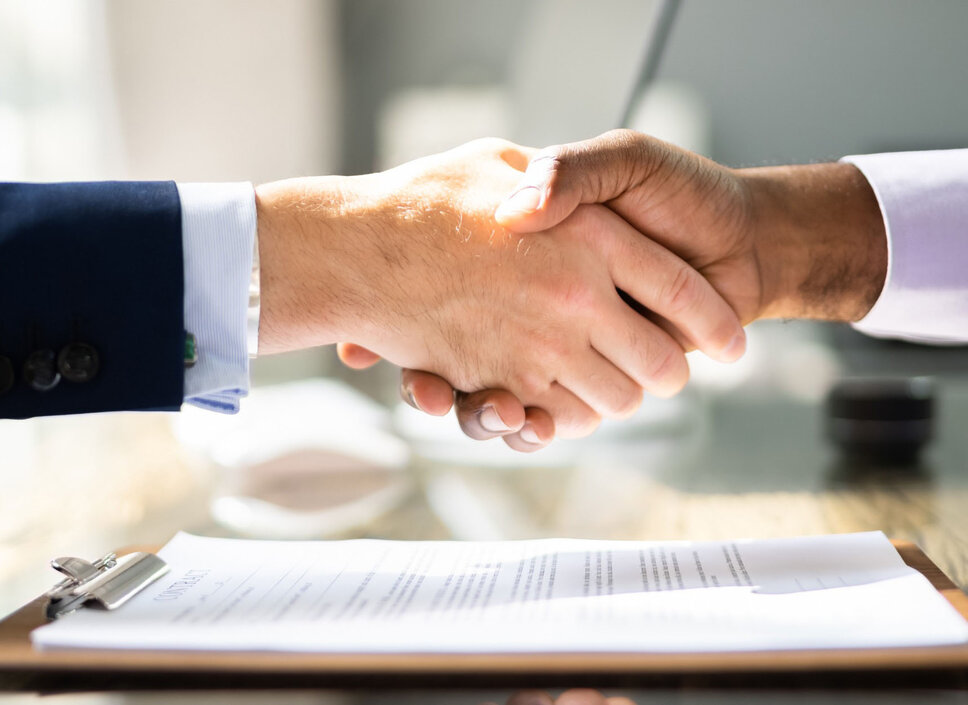 Podání rukou dvou podnikatelů při podpisu smlouvy, která symbolizuje partnerství společností weba Werkzeugbau a Meprotec v oblasti procesní technologie pro kalení v lisu