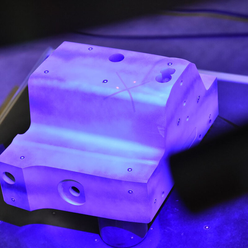 Ocelová destička je vystředěna na otočném stole v technické laboratoři. 3D skener umístěný nad otočným stolem objekt pečlivě digitalizuje a analyzuje. To ilustruje iniciativu společnosti weba v oblasti digitalizace při zajišťování kvality.