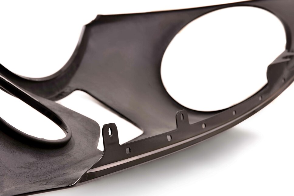 Detail of a composite component with complex contours, cut-outs and mounting points for use in lightweight design.