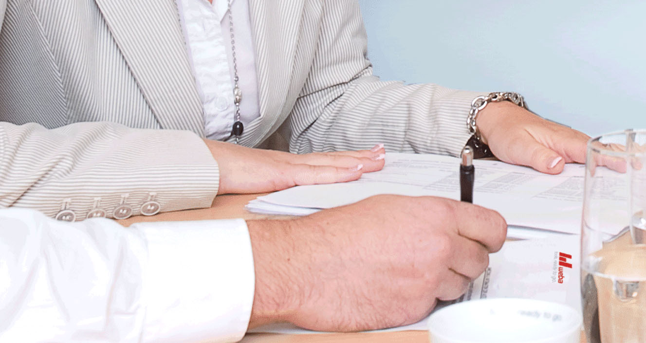 Two people reviewing documents and project files in an office.